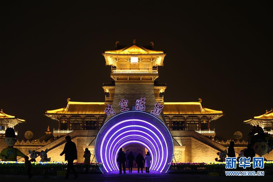 1月20日，游客穿越彩灯组成的“时空隧道”进入庙会展区。  新华社发（杨东 摄）