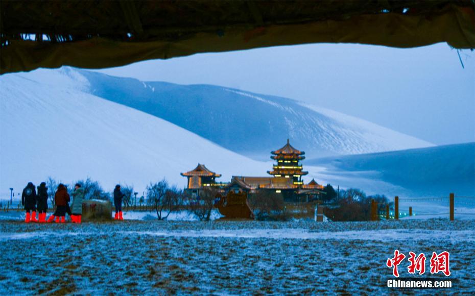 1月19日，古郡敦煌迎来新年的第一场雪，雪后初霁，大漠沙海银装素裹，著名景点鸣沙山月牙泉现“沙雪交融”的美景，不少游客骑骆驼畅享雪后大漠，体验难得一遇的雪漠风光、丝路风情。王斌银 摄