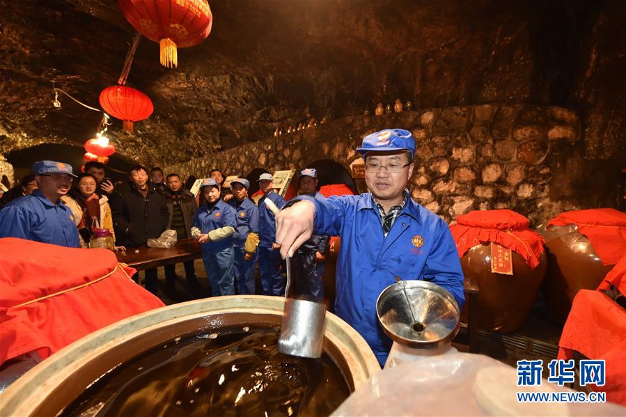 1月27日，在广西桂林象鼻山岩洞内，工作人员在打“年酒”。  　　当日，广西桂林象鼻山下的酒窖开门迎客，市民们排队进洞打“年酒”。“打壶好酒好过年”是桂林的民俗文化之一，象鼻山岩洞温度常年保持在20摄氏度左右，这里存有放了数年甚至数十年的陈酒佳酿。  　　新华社发（唐艳兰 摄）