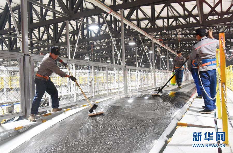 2月12日晚，济南东动车所的车皮清洁工在对一列复兴号进行车皮清洁作业。新华社记者王凯摄