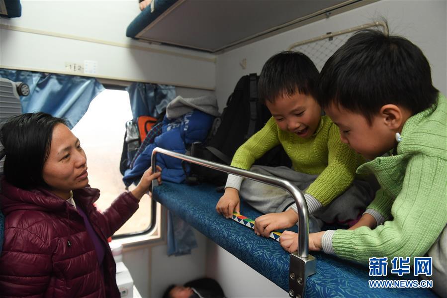 2月12日，在由合肥开往广州的T3089次临客列车上，来自安徽庐江县的双胞胎王佳文（右二）和王佳斌在铺位上玩耍。父母带着他们前往广州打工。