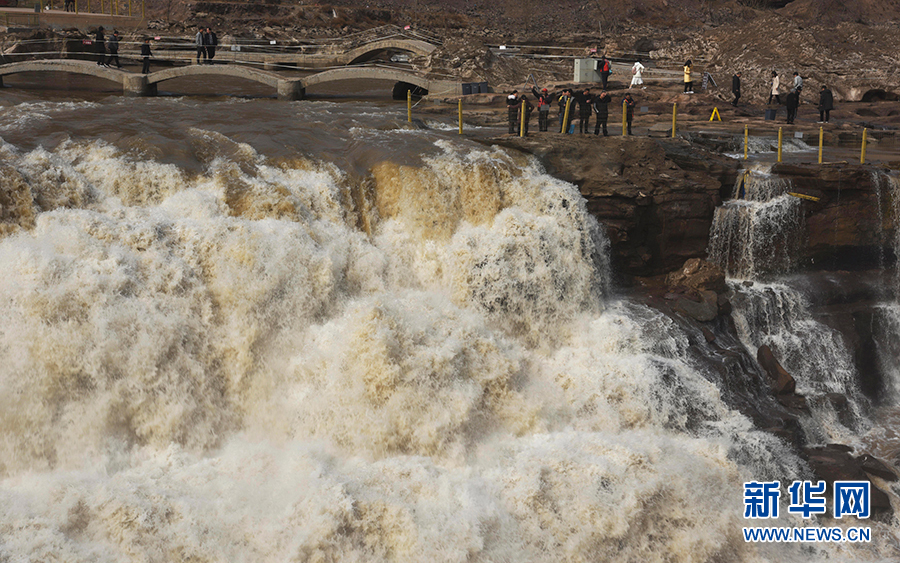 3月3日，游客在黄河壶口瀑布景区游览。近日，随着气温回暖，受上游融冰开河速度加快影响，黄河壶口瀑布水量增大，气势磅礴。 新华社发（吕桂明 摄）