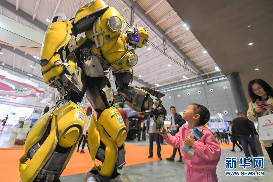 5月15日，在长沙国际工程机械展览会上，小朋友和机器人互动。