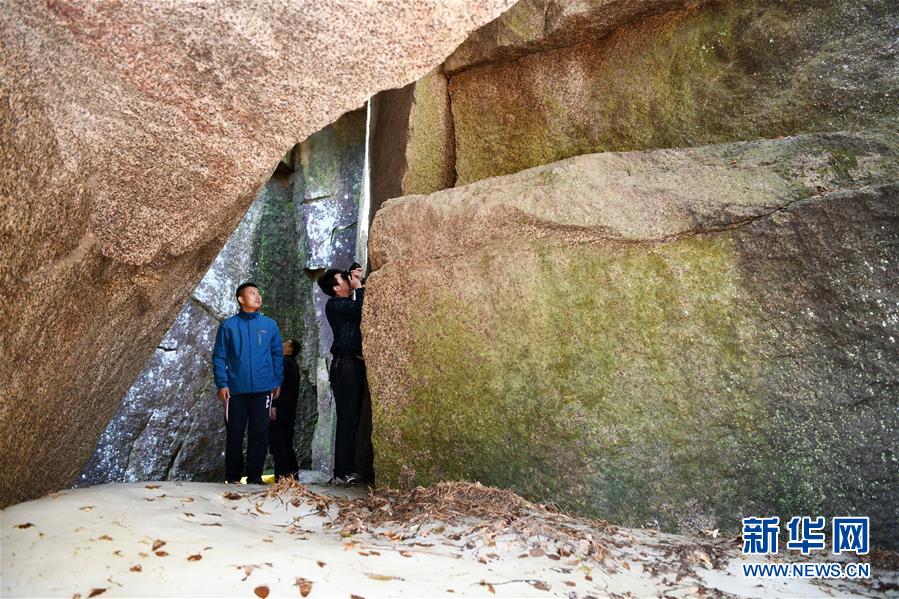 5月15日，游客在黑龙江小兴安岭石林国家森林公园一处有着厚厚冰层的石洞内游览。