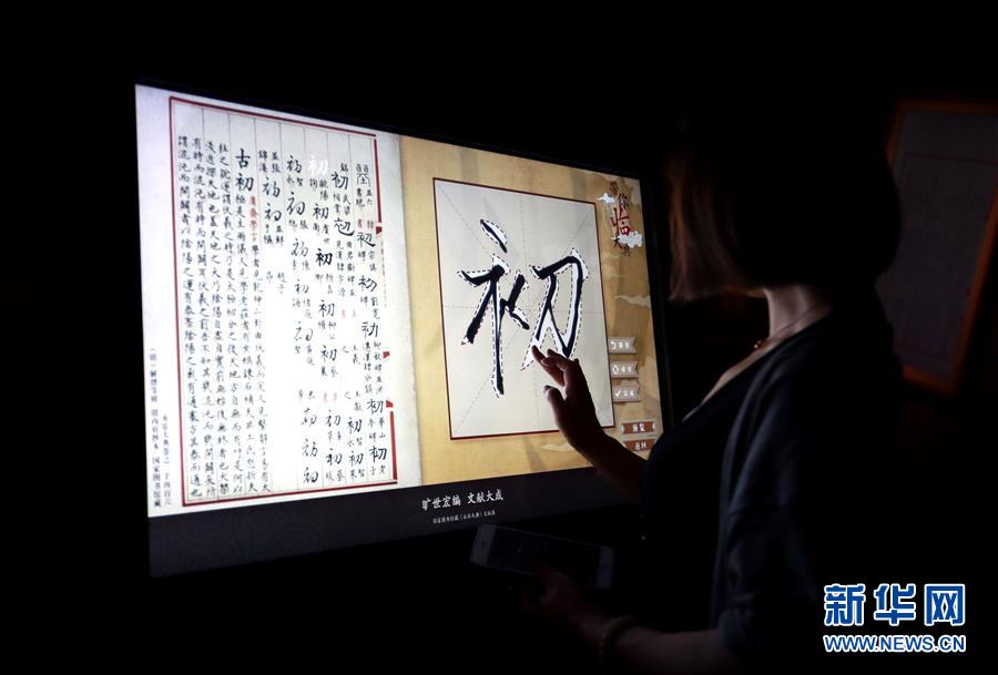 5月18日，观众在电子屏幕上临摹《永乐大典》原文。