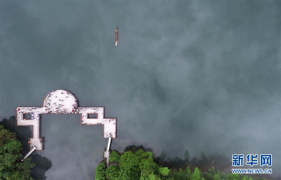 5月25日清晨，一艘小船划过小东江江面，吸引游人驻足（无人机拍摄）。