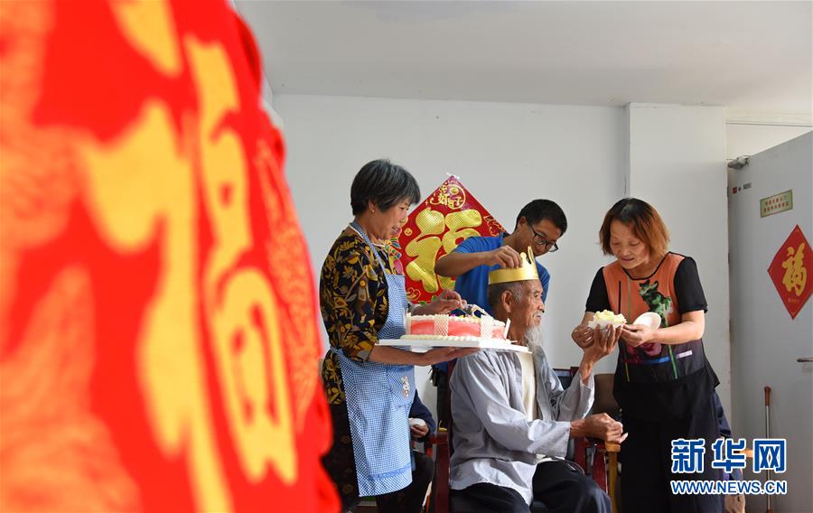 5月27日，杨青红（右一）和丈夫陈德军（右二）给养老中心的一名老人过生日。