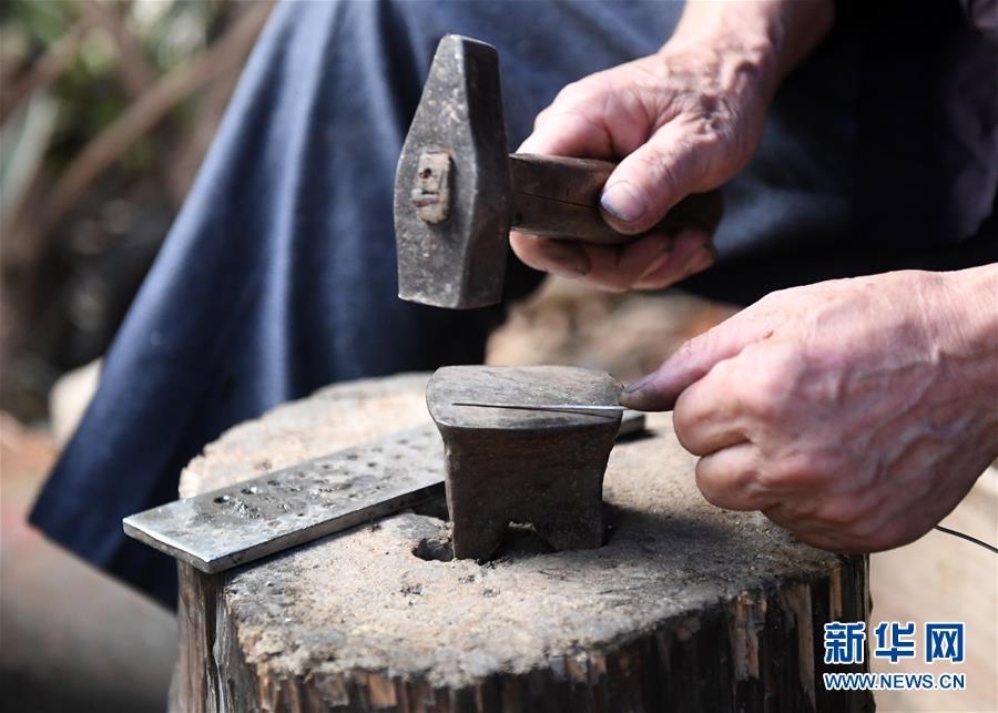 5月29日，在广西融水苗族自治县融水镇，银匠陈四先在打造苗族银饰。