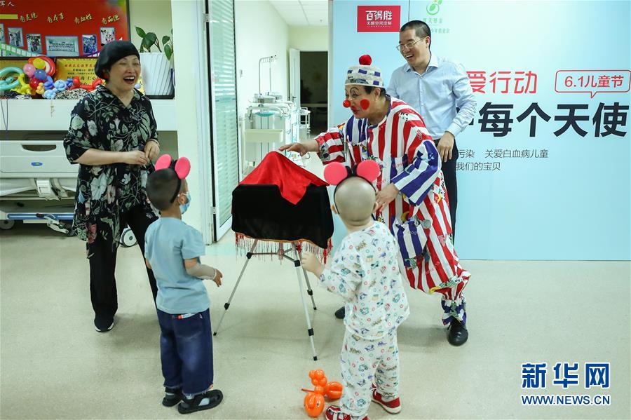 5月30日，志愿者“小丑叔叔”和工作人员与白血病患儿做游戏。