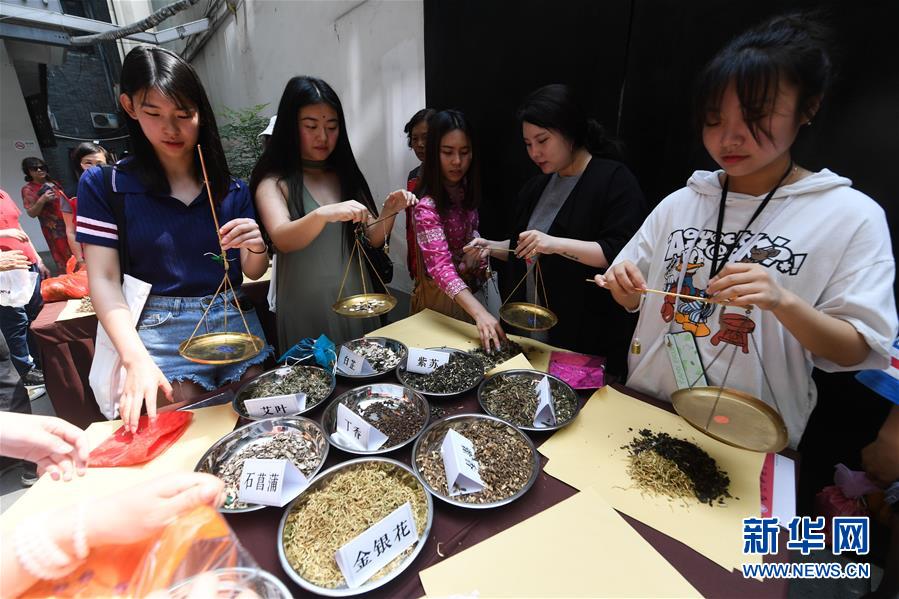 6月5日，市民和游客在张同泰国药馆体验传统端午香包的制作。