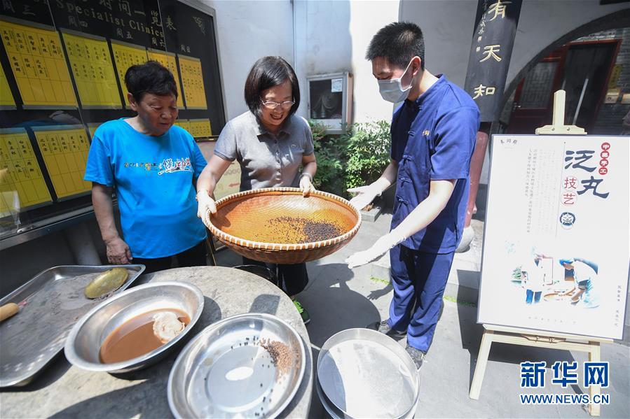 6月5日，市民在张同泰国药馆工作人员的指导下体验传统药丸制作技艺。