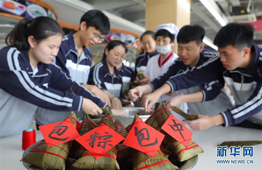 6月4日，浙江省诸暨市海亮高级中学的高考生在学校食堂包粽子，讨个好彩头。
