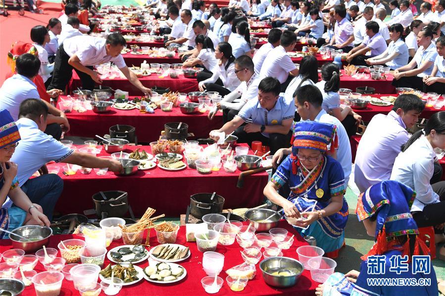 6月15日，瑶族同胞在广西恭城瑶族自治县县城恭城油茶小镇为打好的油茶添加辅料。