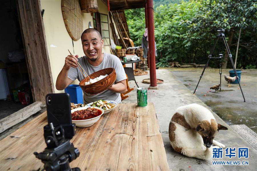6月19日，在进行“吃播”时，蒋金春家的猫一直蹲在旁边盯着鱼，蒋金春索性和猫说起话来。