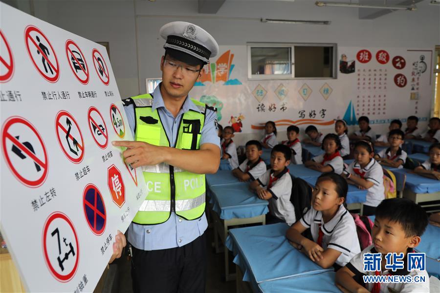 6月27日，在山东省滨州市博兴县第一小学，交警教小学生认识交通标志。