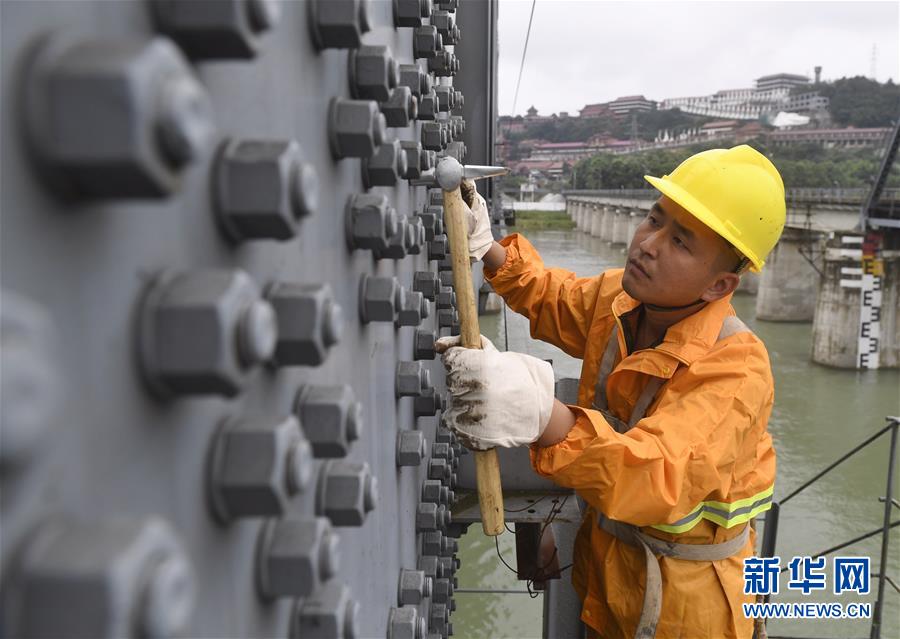 7月11日，工作人员在检查涪江铁路大桥的钢梁。