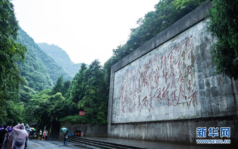 游客从刻有《忆秦娥·娄山关》的石壁前经过（7月4日摄）。