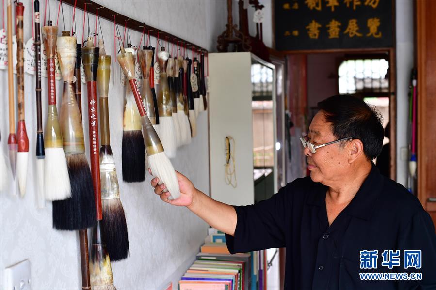 7月11日，在河南省宁陵县，刘腾龙毛笔制作技艺第五代传承人刘兰亭查看刘腾龙笔庄制作的各式毛笔。