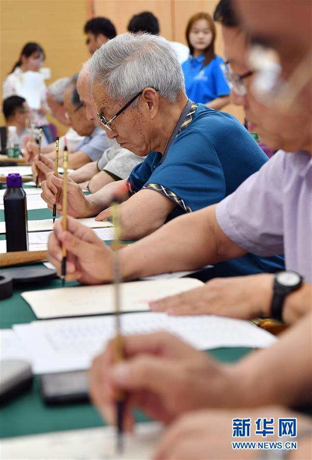 7月16日，陕西师范大学退休教师屈培恒（中）在书写录取通知书。