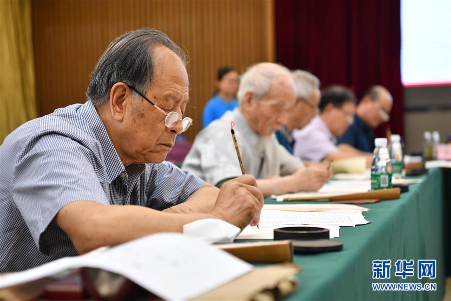 7月16日，陕西师范大学退休教师耿征（左一）在书写录取通知书。