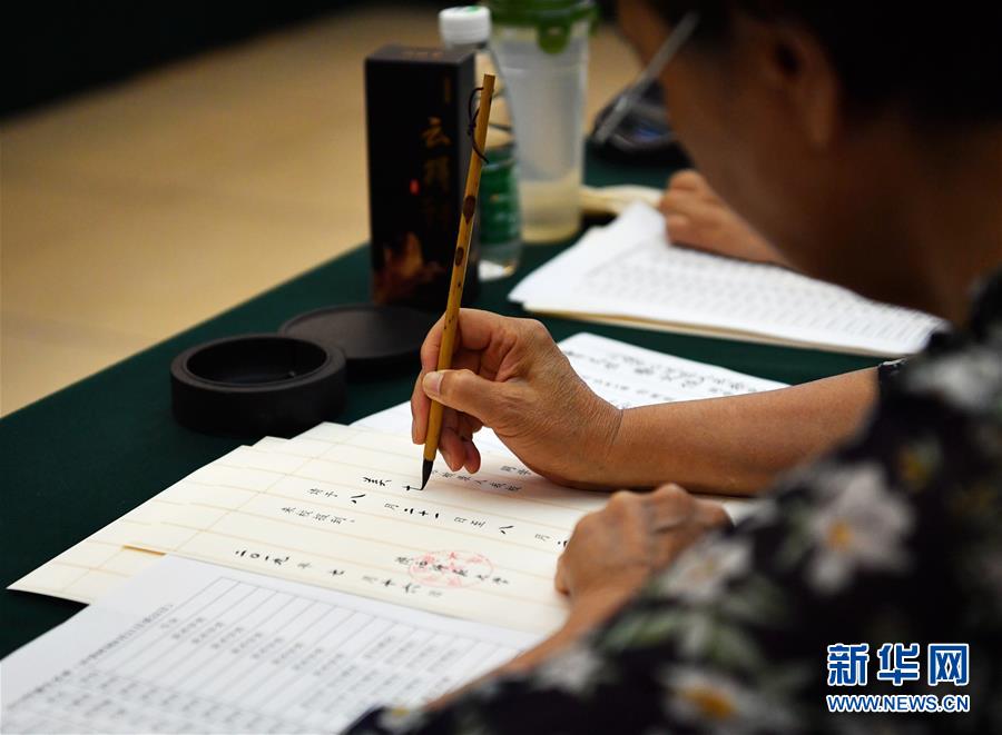 7月16日，陕西师范大学退休教师王书欣在书写录取通知书。