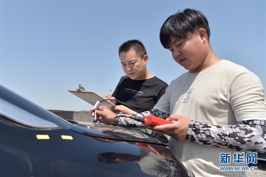 7月17日，在新疆吐鲁番自然环境试验研究中心，检测人员在整车静态区进行汽车漆膜厚度检测。