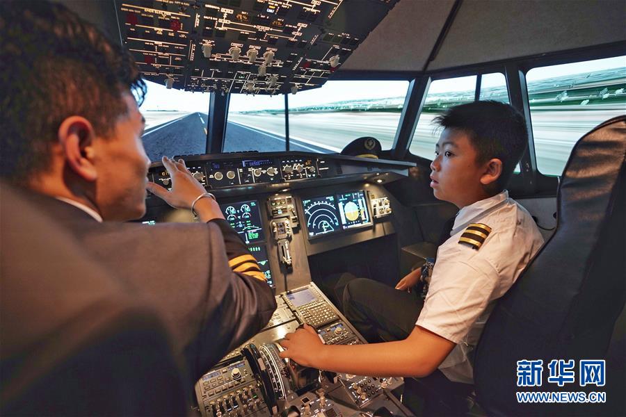 7月17日，夏令营学员（右）在学习空客A320模拟机的驾驶知识。