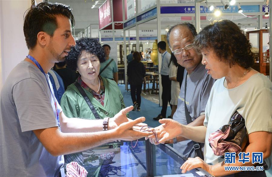 7月17日，在第二届东北亚文化艺术博览会上，外国参展商向观众介绍展品。